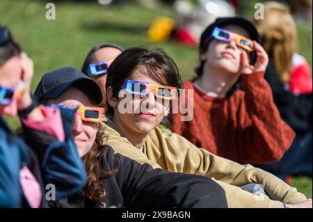 Viewers watch the solar eclipse of 2024 from the lawn of the Vermont State House, Montpelier, Vermont, USA, April 8, 2024. Stock Photo