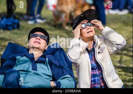 Viewers watch the solar eclipse of 2024 from the lawn of the Vermont State House, Montpelier, Vermont, USA, April 8, 2024. Stock Photo