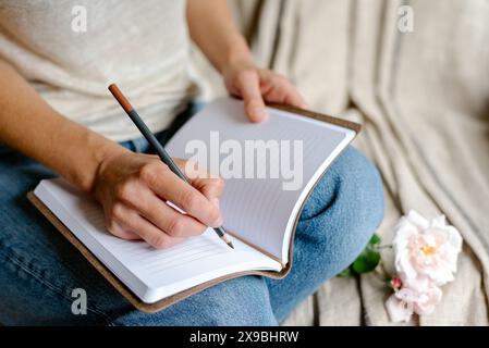 Woman makes notes in a notepad. Stock Photo