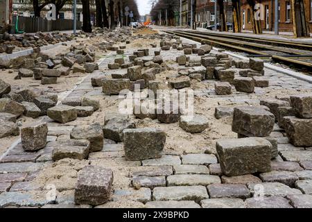 Close-up of historic cube-shaped hammered and chiseled natural granite paving stones on an unfinished street pavement Stock Photo
