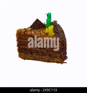 A piece of layered chocolate cake with butter cream with extinguished candles isolate on a white background close-up. Stock Photo