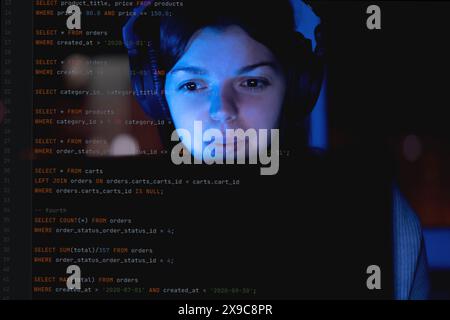 Girl works on a laptop at night, coding and creating project. Stock Photo