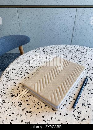 Beige notebook and pen on a table in cafe Stock Photo