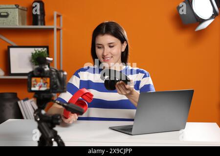 Smiling technology blogger recording video review about headphones at home Stock Photo