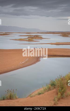 The lake in the middle of the desert. A unique landscape of Wuhai city in Inner Mongolia, China. Dramatic sky with copy space for text Stock Photo