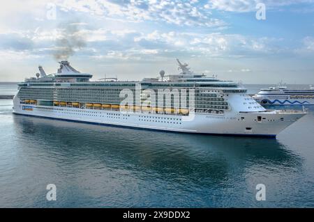 Cruise ship INDEPENDENCE OF THE SEAS, owned & operated by Royal Carribean International, is maneuvering in the port of Livorno, Italy for its stopover Stock Photo