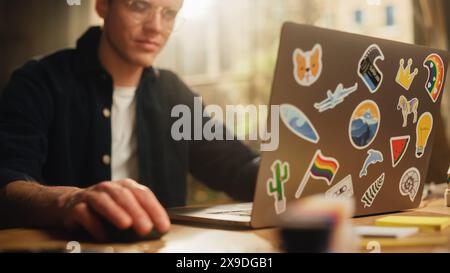 Focused Male Software Engineer Codding on Laptop Computer and Working With Inspiration in Modern Loft Flat. Man Creating New Mobile Application. Freelancer Doing Remote Work. Stock Photo