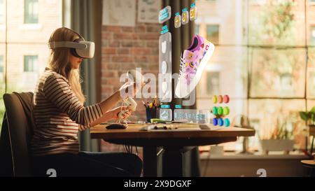 Talented Female Shoes Designer Wearing Virtual Reality Headset and Using Controllers to Design a Fashionable Sneaker in Augmented Reality Software. Woman Working on Custom Digital Footwear at Home. Stock Photo