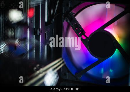 Close-up of a computer cooling fan with RGB lighting inside a PC case. Stock Photo