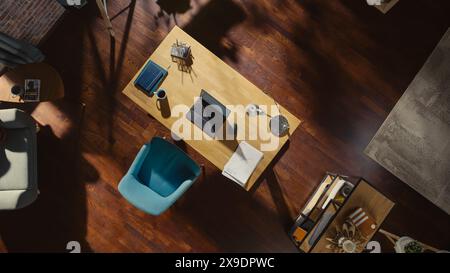 Top View Shot of Home Office: Stylish Empty Home Office Space, Wooden Desk, Laptop Computer, Wooden Floores, Very Tastefully Done. Contemporary Cozy Apartment with No Peope. Stock Photo