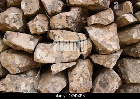 Natural background of ancient rocks that make up a retaining wall in the natural environment Stock Photo