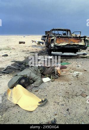 5th March 1991 The body of an Iraqi soldier lies next to a burnt-out pick-up truck in the desert on Route 801, the road to Um Qasr, north of Kuwait City. He was part of an Iraqi military convoy, fleeing to Iraq, that was attacked about a week before by the USAF. Stock Photo