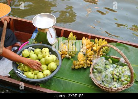 Boat selling guava and Thai Namwa banana on Khlong Lad Mayom floating market in Bangkok, Thailand Stock Photo