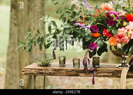Flower arrangement sits on rustic wooden table Stock Photo