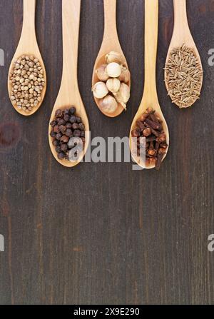 Top View of Assortment of Spices in Wooden Spoons on Wooden Background Stock Photo