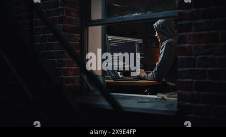 Single-Minded Professional Programmer Obsessively Writing a Code on His Desktop Computer, Late at Night. IT Specialist Ethical Hacker Working on Computer, Finding Software Vulnerabilities Stock Photo