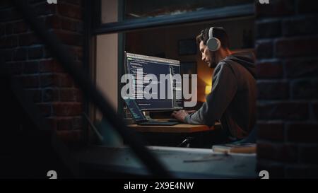 Professional Software Developer Writing Code with Generic Programming Language. Development Interface Mockup. Information Technology Specialist. Remote Work Concept. View From Outdoors into Window. Stock Photo