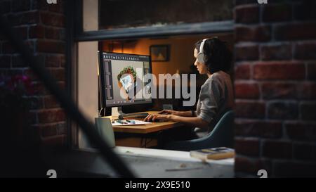 Female Video Game Designer Works on a New 3D Level on Her Personal Computer. Focused Woman Creating Metaverse and Design Video Game. Shot Into the Apartment Window Late at Night. Stock Photo