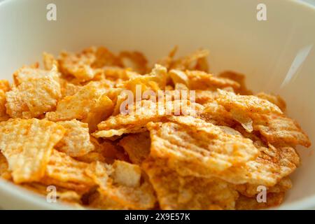 Close up of salty flavored chips in a white bowl Stock Photo