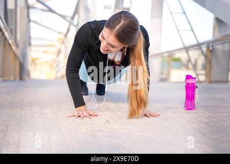 Active and fit young woman athlete doing push-ups outdoors. Stock Photo