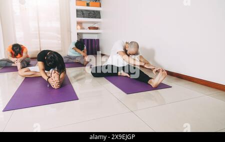 People in Yoga class practicing the Janu Sirsasana pose: The Head to Knee Stock Photo