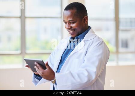 Happy Doctor Using Digital Tablet in Hospital Office Stock Photo