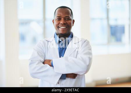 Confident Male Doctor Posing in White Coat in Modern Hospital Stock Photo