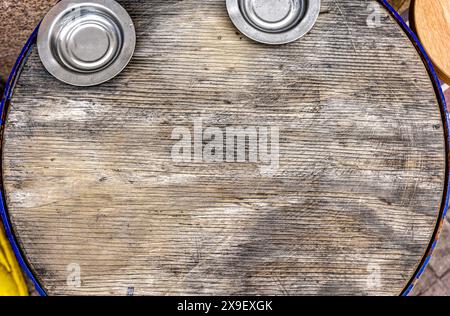 Background of a round table with two metallic plates made with rustic wood. Stock Photo