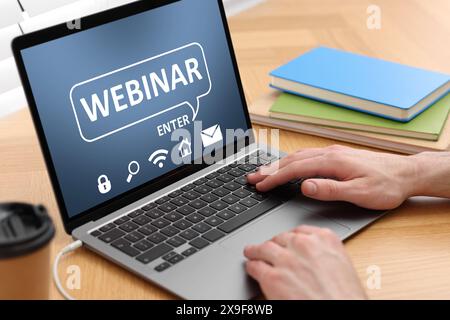 Webinar. Man using laptop at table, closeup Stock Photo
