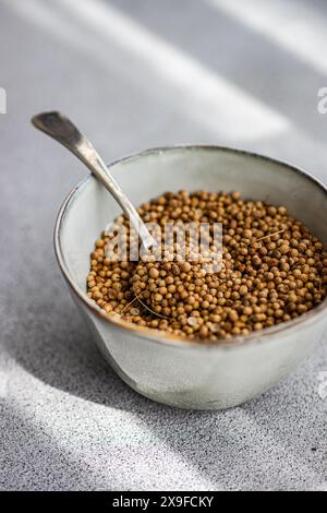 Close-up of a bowl of coriander seeds on a table Stock Photo