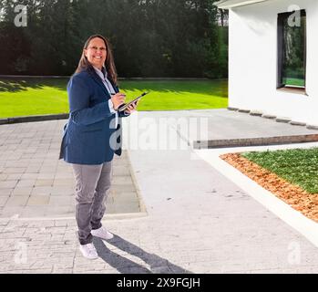 estate agent woman in front of house background Stock Photo