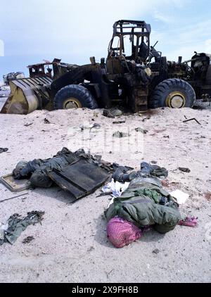 5th March 1991 The bodies of an Iraqi soldiers lie close to a burnt-out Caterpillar wheel loader in the desert on Route 801, the road to Um Qasr, north of Kuwait City. They were part of an Iraqi military convoy, fleeing to Iraq, that was attacked about a week before by the USAF. Stock Photo