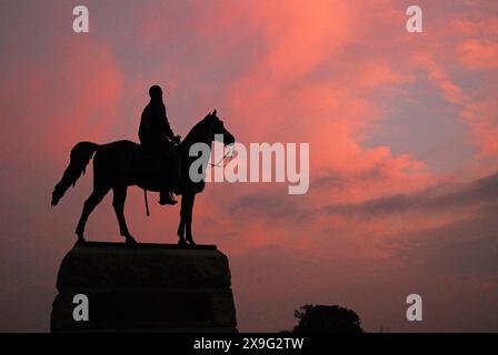 A statue of Union General George Meade is rendered into silhouette against a sunset sky in Gettysburg National Military Park in Pennsylvania Stock Photo