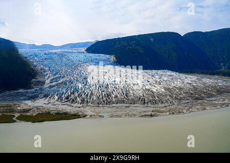 Aerial view of the Taku Glacier which is part of the Juneau Icefield in Alaska, USA - Melting water flowing into the Pacific Ocean displaying evidence Stock Photo