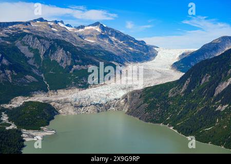 Aerial view of a suspended glacier located along the Taku Inlet which is part of the Juneau Icefield in Alaska, USA - Melting water flowing into the P Stock Photo