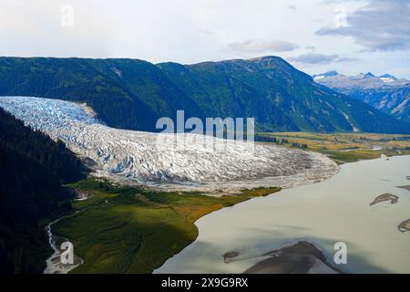 Aerial view of the Taku Glacier which is part of the Juneau Icefield in Alaska, USA - Melting water flowing into the Pacific Ocean displaying evidence Stock Photo