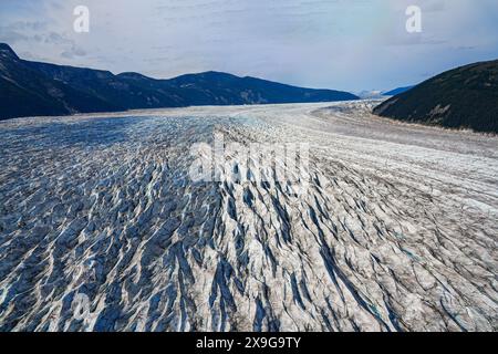 Aerial view of the glaciers located along the Taku Inlet, which are part of the Juneau Icefield in Alaska, USA - Curvy flow of ice covered with shear Stock Photo