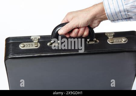 Male hand in a shirt holding briefcase isolated on white background with clipping path. Black premium quality business briefcase in male hand Stock Photo