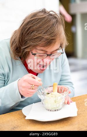 41 yo white woman with the Down Syndrome eating ice cream, Tienen, Flanders, Belgium. Model released. Stock Photo