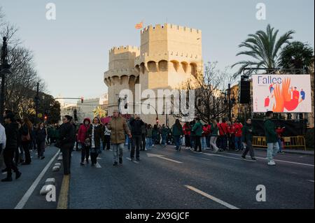 Vibrant crowd gathers near the serranos towers during the las fallas festival, with a 'falles' sign prominently displayed in the background Stock Photo