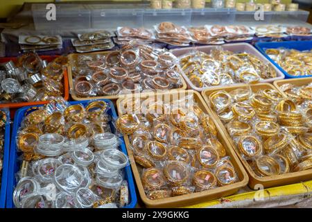 Explore a dazzling collection of traditional Indian bangles meticulously arranged in trays at a vibrant market shop. Stock Photo