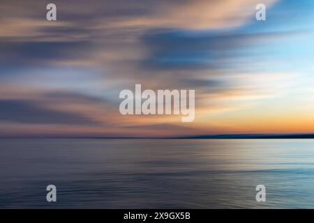 ICM, in camera movement, sunset over the ocean, partly cloudy sky, abstract Stock Photo