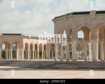 Spacious stone structure with arcades and columns on a square, Tunis in Africa with ruins from Roman times, modern mosques and blue and white houses Stock Photo