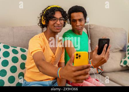 Gay couple listening to music and taking a selfie together at home Stock Photo