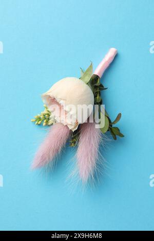 Small stylish boutonniere on light blue background, top view Stock Photo