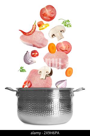 Fresh ingredients falling into saucepan on white background Stock Photo