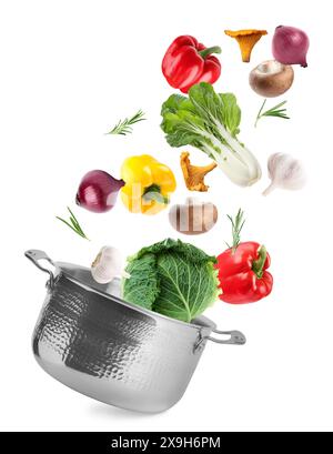 Fresh ingredients falling into saucepan on white background Stock Photo