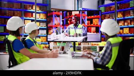 Warehouse Workers Having Video Conference With Man Stock Photo