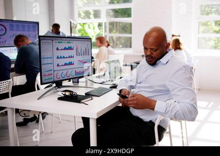 Distracted Businessman Using Mobile Phone In Meeting Stock Photo