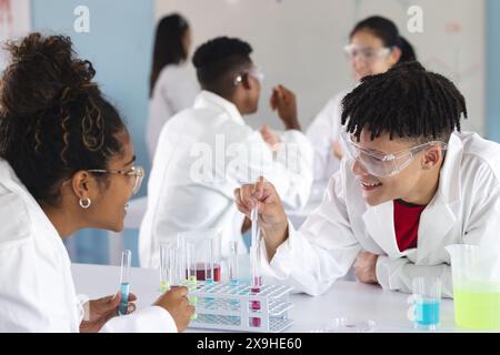 Diverse students engage in a chemistry experiment at high school Stock Photo